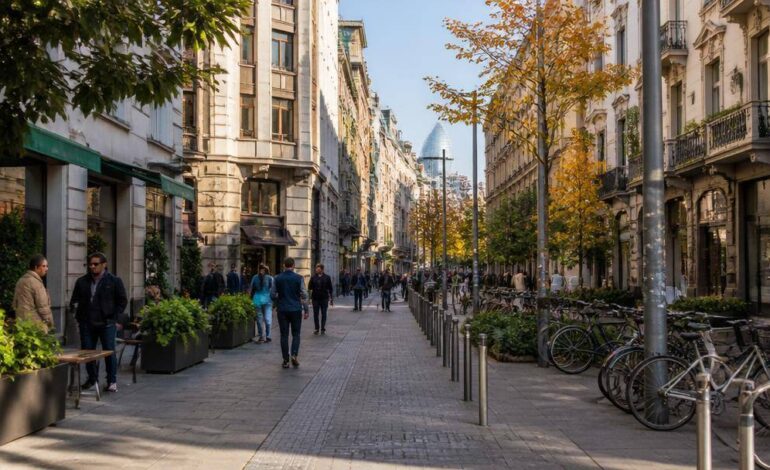 Strada commerciale milanese animata da negozi di vicinato, piccoli locali e cittadini a passeggio.